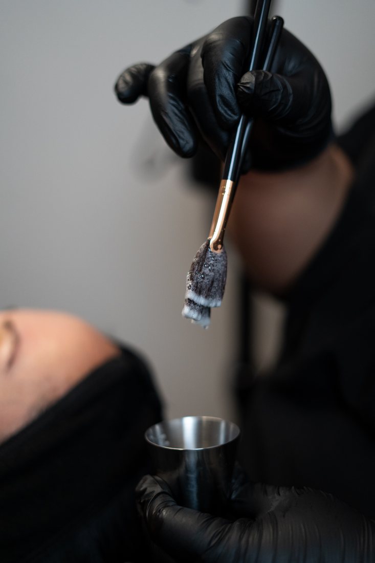 Brush lifted from a steel bowl during a facial